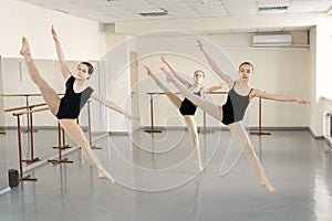 Choreographed dance by a group of graceful pretty young ballerinas practicing during class before performance.