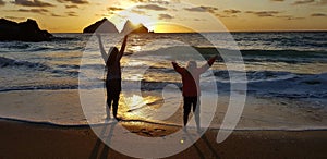 young girls doing yoga at a sunset cornish beach