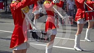 Young girls drummer in red at the parade. Close-up of female hands drummers are knocking in the drum of their sticks