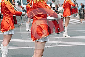 Young girls drummer in red vintage uniform at the parade. Street performance of festive march of drummers girls in red