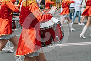 Young girls drummer in red vintage uniform at the parade. Street performance of festive march of drummers girls in red