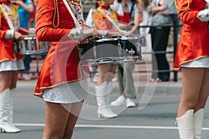 Young girls drummer in red vintage uniform at the parade. Street performance of festive march of drummers girls in red