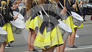 Young girls drummer in yellow black vintage uniform at parade. Street performance. Parade of majorettes