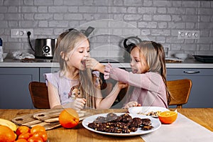 Young girls eating biscuits at home photo