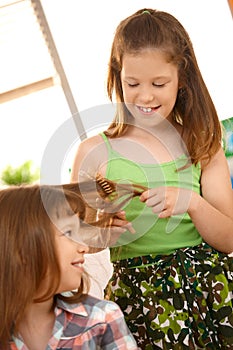 Young girls enjoying combing hair