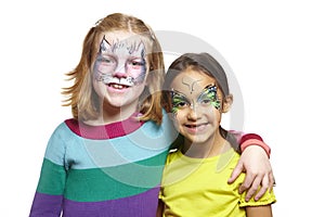 Young girls with face painting of cat and butterfly