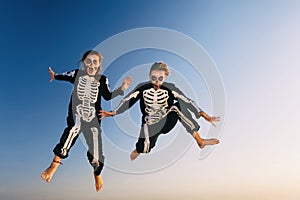Young girls in Halloween costumes jump high with fun