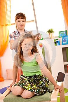 Young girls having fun combing hair