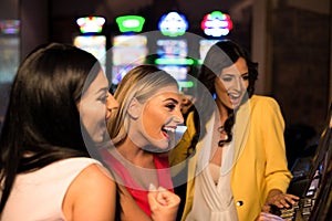 Young Girls Playing Automat Machine in a Casino photo