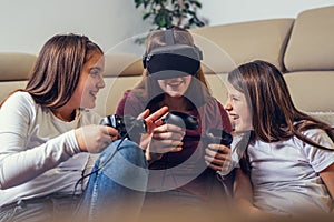 Young girls playing with video games at home.