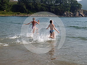 Young girls running to the sea