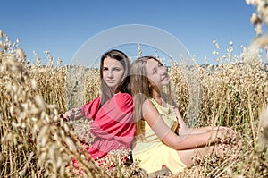 Young girls sitting in a field in the sun