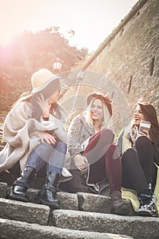 Young girls sitting on the stairs at the public park and h