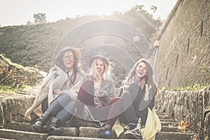 Young girls sitting on the stairs at the public park and h