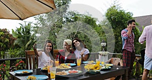 Young Girls Sitting At Table Taking selfie Photo While Men Group Cooking Barbecue Friends Gathering On Summer Terrace