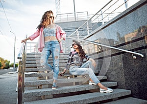 Young girls with skateboard sitting on the stairs