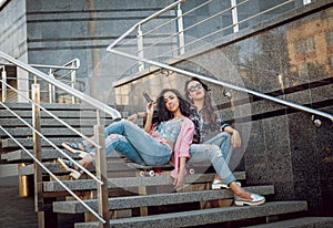 Young girls with skateboard sitting on the stairs