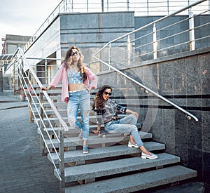 Young girls with skateboard sitting on the stairs