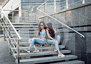 Young girls with skateboard sitting on the stairs