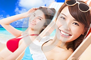 Young girls sunbathing and lying on a beach chair