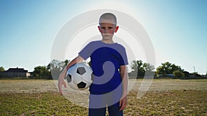 Young goalkeeper with the ball at hand near the goal post.