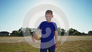 Young goalkeeper with the ball at hand near the goal post.