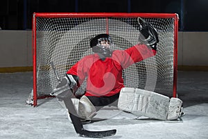 Young goalkeeper catching a puck