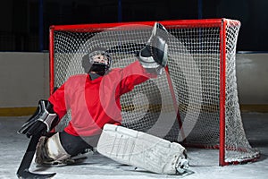 Young goalkeeper catching a puck