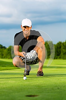 Young golf player on course putting