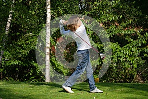 Young golfer performs a golf shot