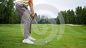 Young golfer in uniform making a hit with a club