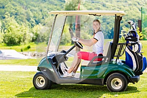 Young golfers driving in a cart on a golf course