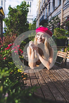 Young gorgeous female with good mood dressed in pink beret smiling for someone