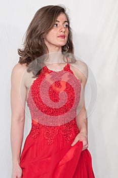 Young, gorgeous model dressed red in a wedding and evening style. Sleeveless dress in red lace.