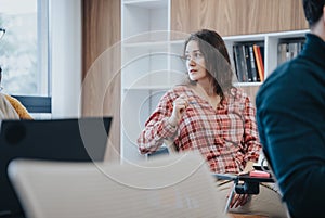 Young, gorgeous woman in casual office environment engaged in discussion.