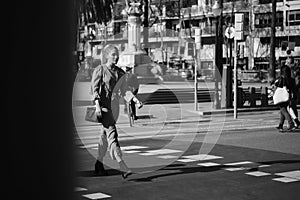 Young gorgeous woman confidently crossing the road along street. Black and white photo