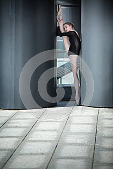 Young graceful ballerina in black bathing suit on