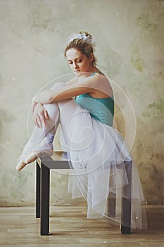 Young and graceful ballerina in pointe shoes and a tutu dances in the studio. Choreography and dancing classes concept.
