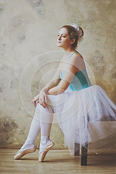 Young and graceful ballerina in pointe shoes and a tutu dances in the studio. Choreography and dancing classes concept.