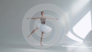 Young graceful ballerina in pointe shoes and white ballet tutu makes pirouette. Shot on a white background in the