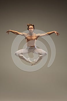 Young and graceful ballet dancer isolated on studio background. Art, motion, action, flexibility, inspiration concept.