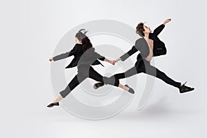 Young and graceful ballet dancers in minimal black style isolated on white studio background