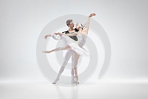 Young graceful couple of ballet dancers on white studio background