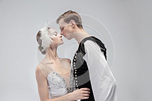 Young graceful couple of ballet dancers on white studio background