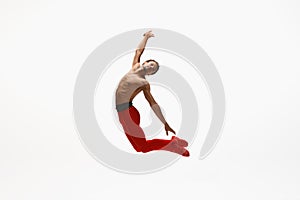 Young graceful male ballet dancer dancing on white studio background