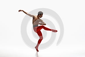 Young graceful male ballet dancer dancing on white studio background