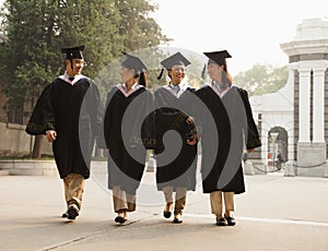 Young Graduates Walking Across Campus