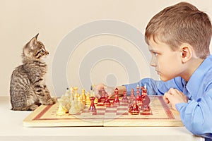 Young grandmaster with cute kitten plays chess.