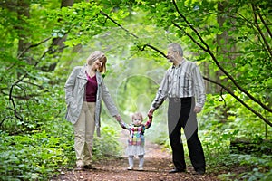 Young grandparents walking with their baby granddaughter