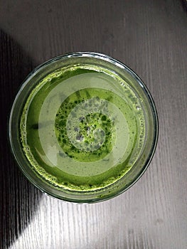 Mladý zelený jačmeň alebo chlorella zelené jedlo v pohári alebo miske.